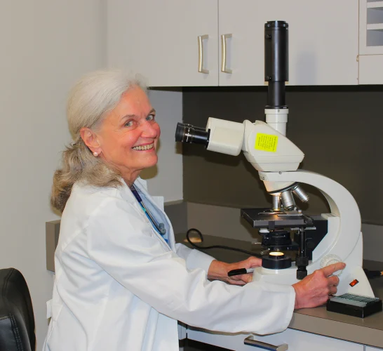 Portrait of Phoebe Rich conducting research with a microscope - dermatology clinic in Portland, Oregon